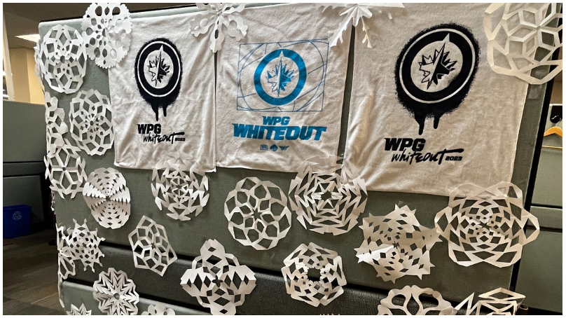 A cubicle decorated with snowflakes and Winnipeg Jets towels