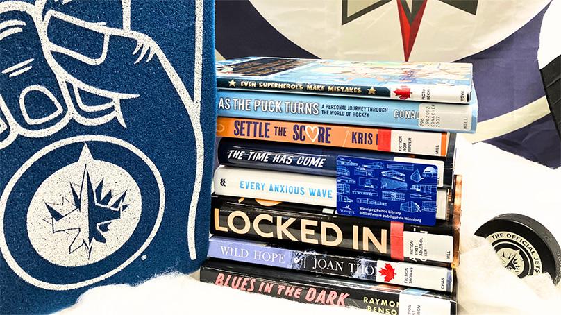 Stack of books with Winnipeg Jets decorations around them