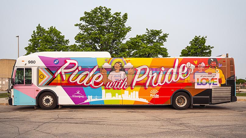 Winnipeg Transit bus with a Pride graphic design on the side with 'Ride with Pride'