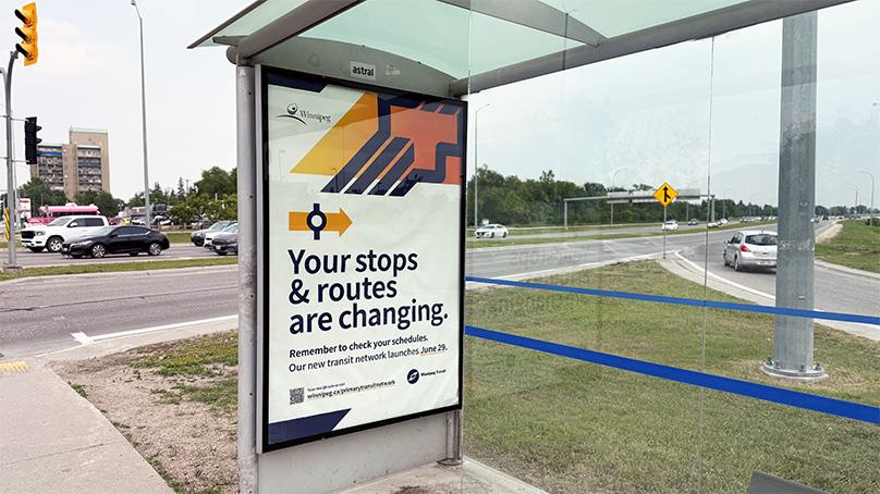 Bus stop with an advertisement about the Winnipeg Transit Network