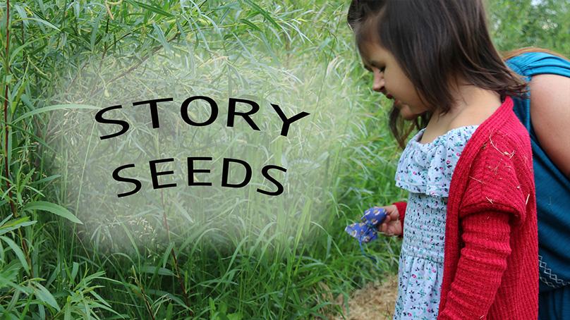 Woman and young girl planting flowers in front of tall grass