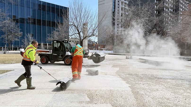 Crews power sweeping sand in Millennium Park after winter