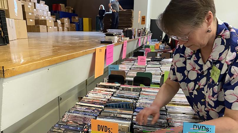 Person looking at a table of books for sale
