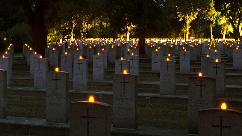 Cemetery with candles lit on each grave headstone