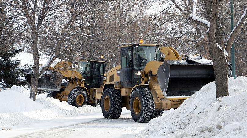 Front end loaders clearing a street in Winnipeg.