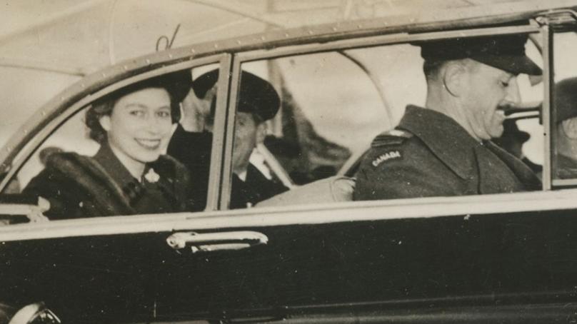 Princess Elizabeth, Duchess of Edinburgh (later Queen Elizabeth II) and the Duke of Edinburgh (or Prince Philip) ride in the back of a car.