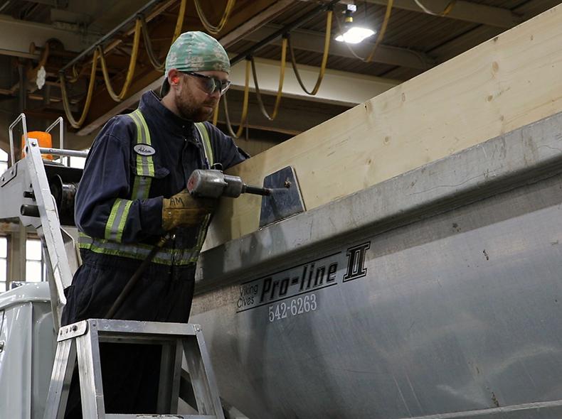 A worker converts a truck to so it can be used to spread sand.