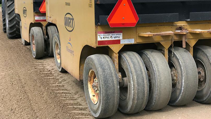 Crews do maintenance on a section of gravel road.