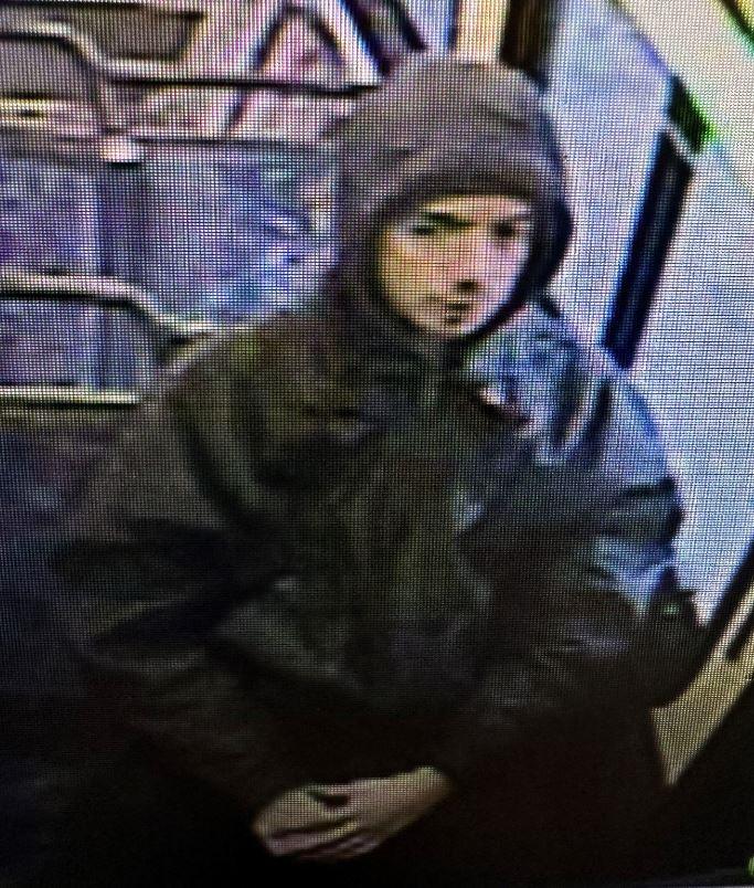 male with hood up on a bus