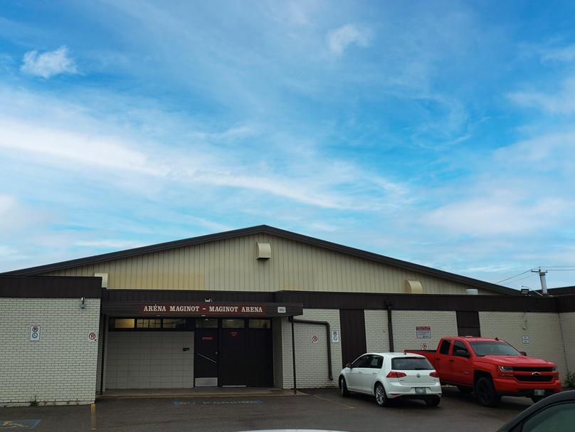 Des véhicules blancs et rouges garés dans le terrain de stationnement devant l’aréna Maginot