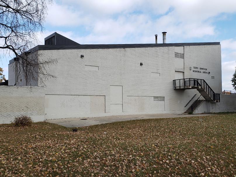 Leaves lie on the grass in fall in front of the Terry Sawchuk Arena.