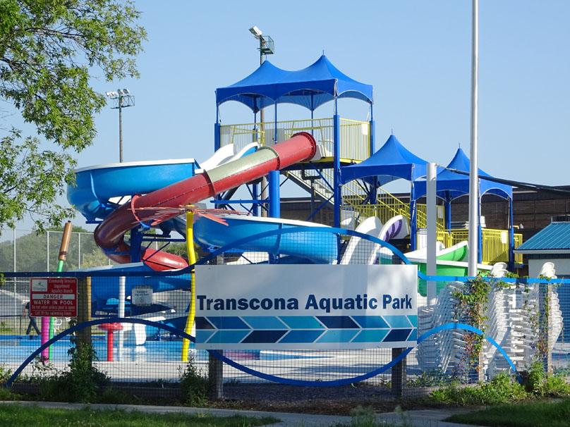 Waterslides rise up behind the Transcona Aquatic Park signage.
