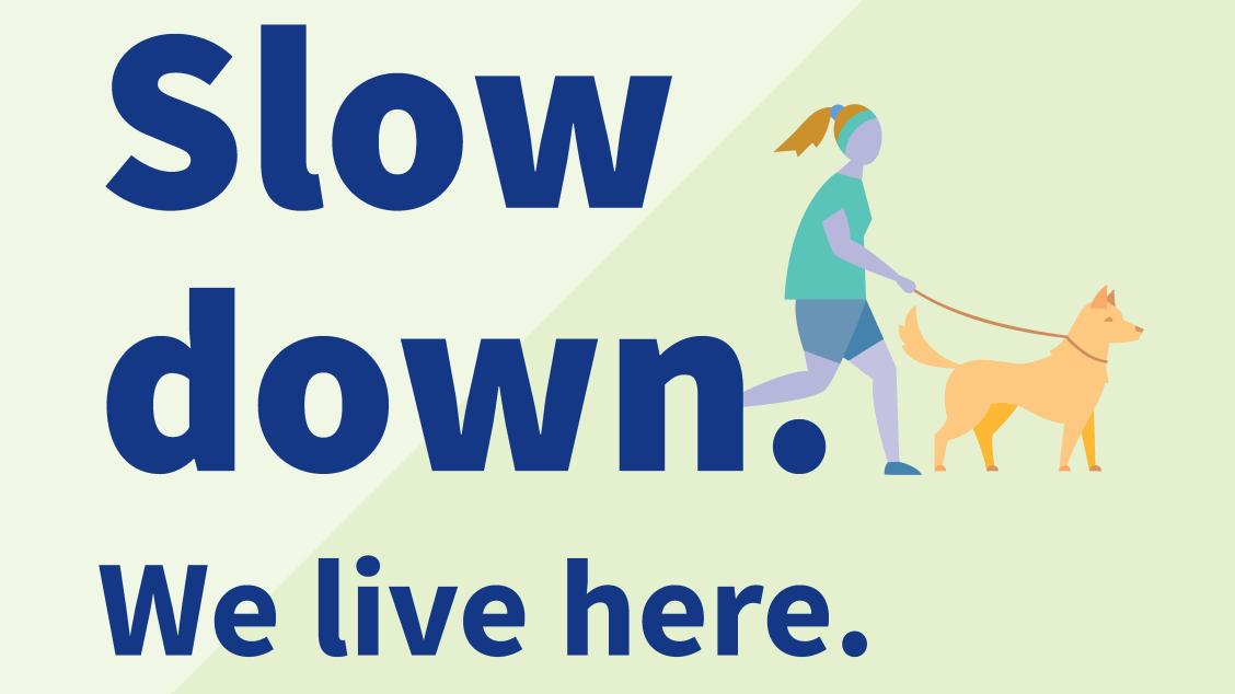 One bilingual lawn sign features a person walking a dog with the message on one side reading ‘Slow down. We live here.'