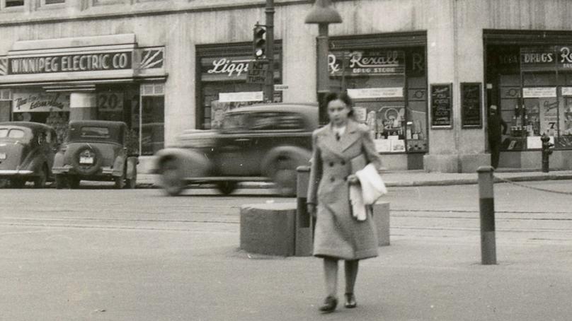A person crossing Portage Avenue and Vaughn Street in 1939. Credit: City of Winnipeg Archives.