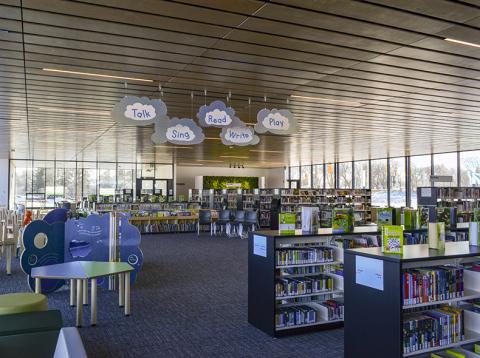 Interior of Transcona Library, with book stacks, tables and decorative signage